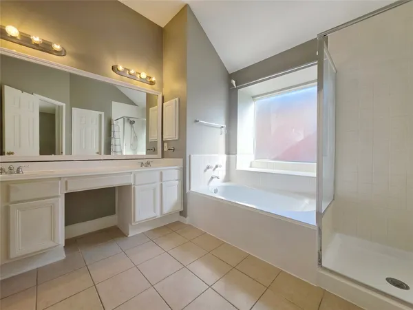 a spacious bathroom with a tub sink and mirror