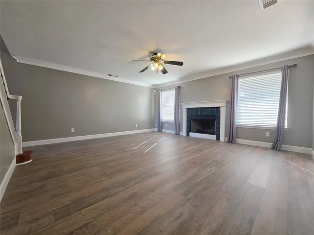an empty room with windows fireplace and a sink