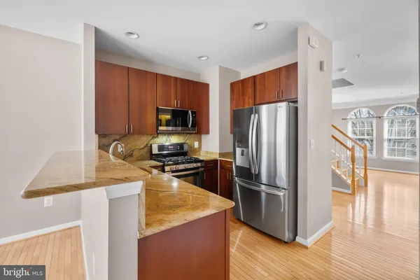 a kitchen with granite countertop a sink and a refrigerator