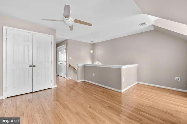 a view of a bedroom with wooden floor and a window