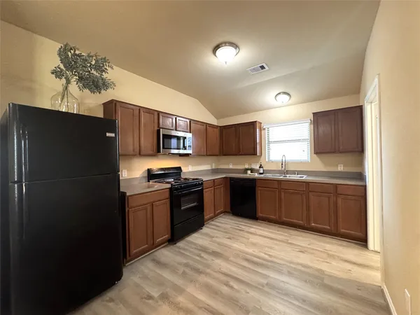 a kitchen with stainless steel appliances granite countertop a refrigerator and a sink