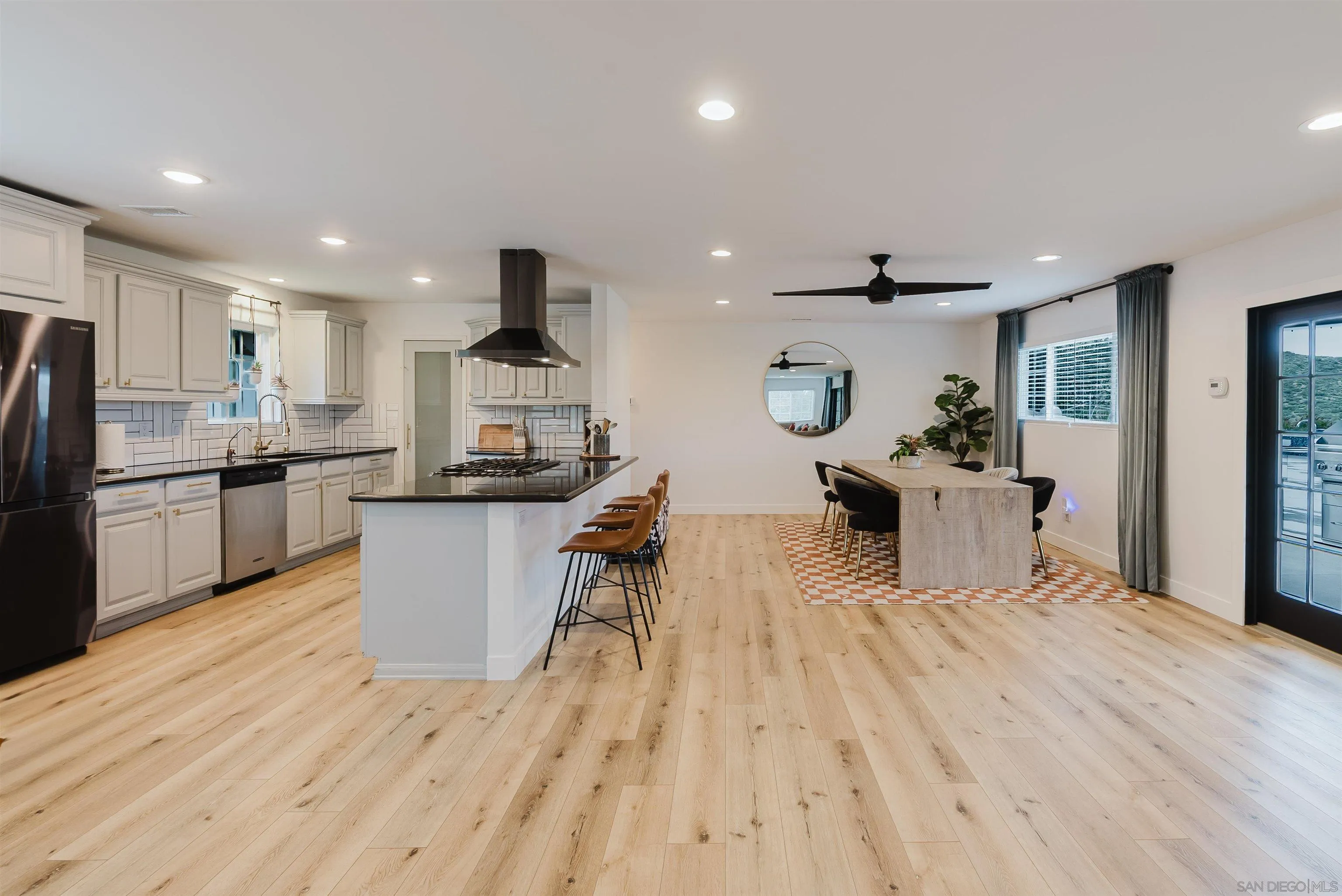 11911 Rocoso Road Lakeside, CA 92040 - Photo 13 of 32 a kitchen with stainless steel appliances kitchen island granite countertop a refrigerator a stove and a wooden floors