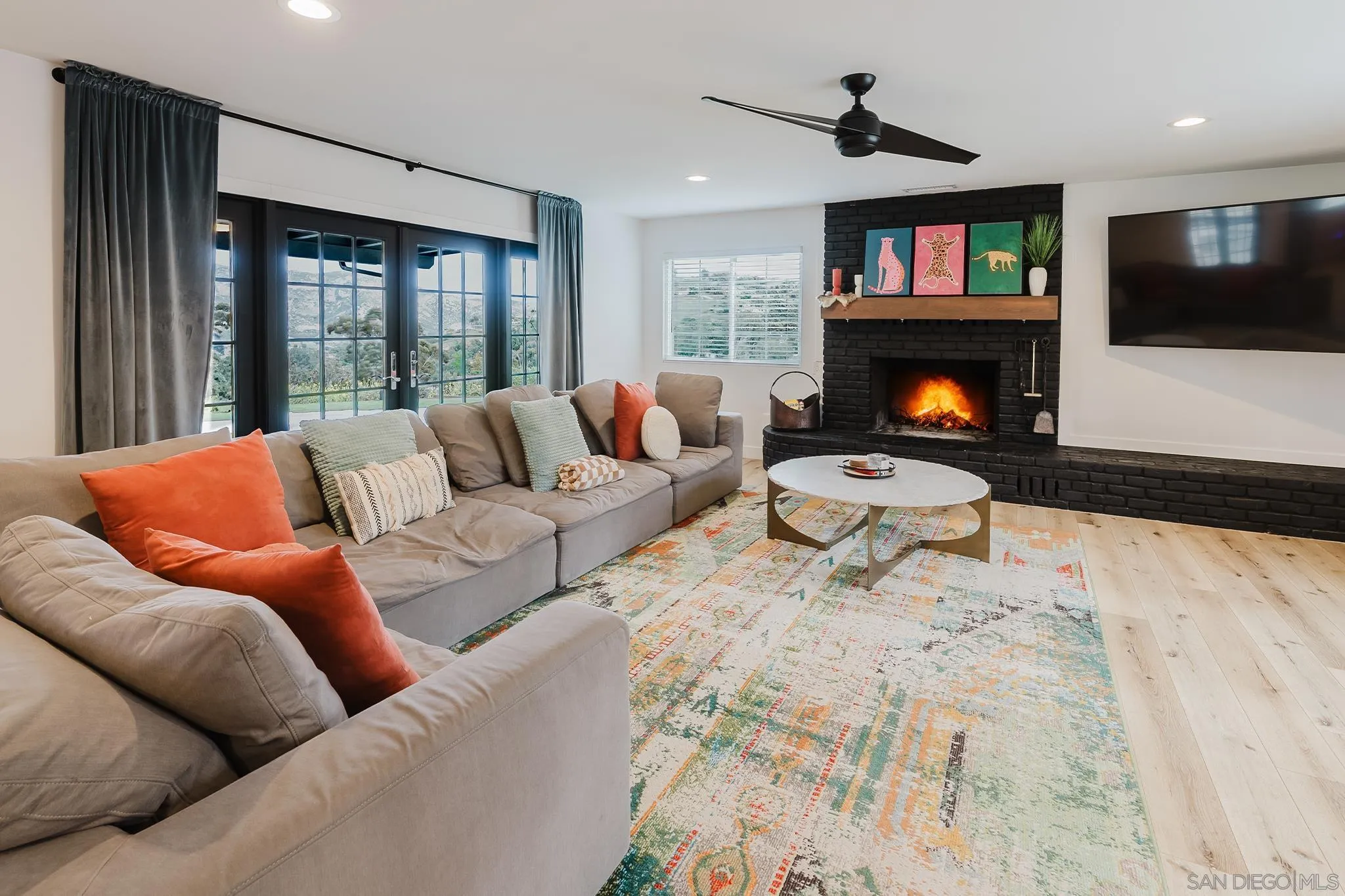 11911 Rocoso Road Lakeside, CA 92040 - Photo 10 of 32 a living room with furniture a flat screen tv and a fireplace