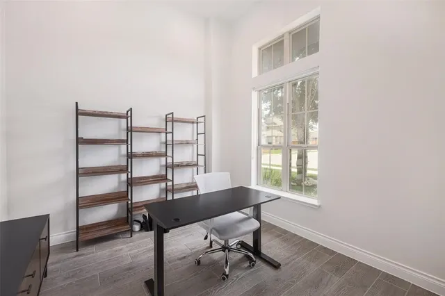a view of a workspace with furniture and a window