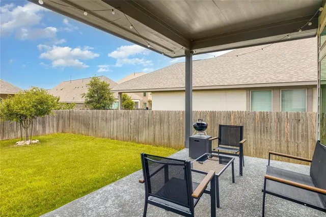 a view of a backyard with plants and outdoor seating