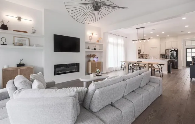 a living room with furniture a flat screen tv and a fireplace