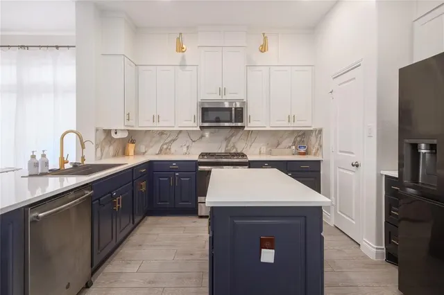 a kitchen with kitchen island granite countertop a sink stove and refrigerator