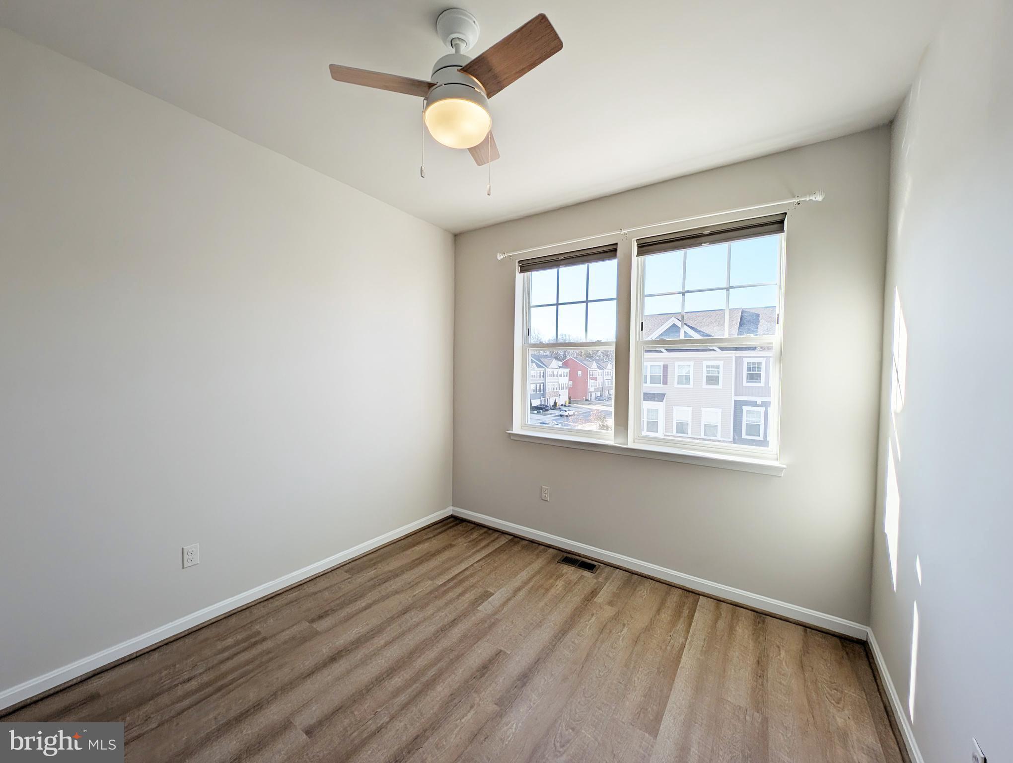 3106 Laurel Hill Road Hanover, MD 21076 - Photo 14 of 27 an empty room with wooden floor fan and windows