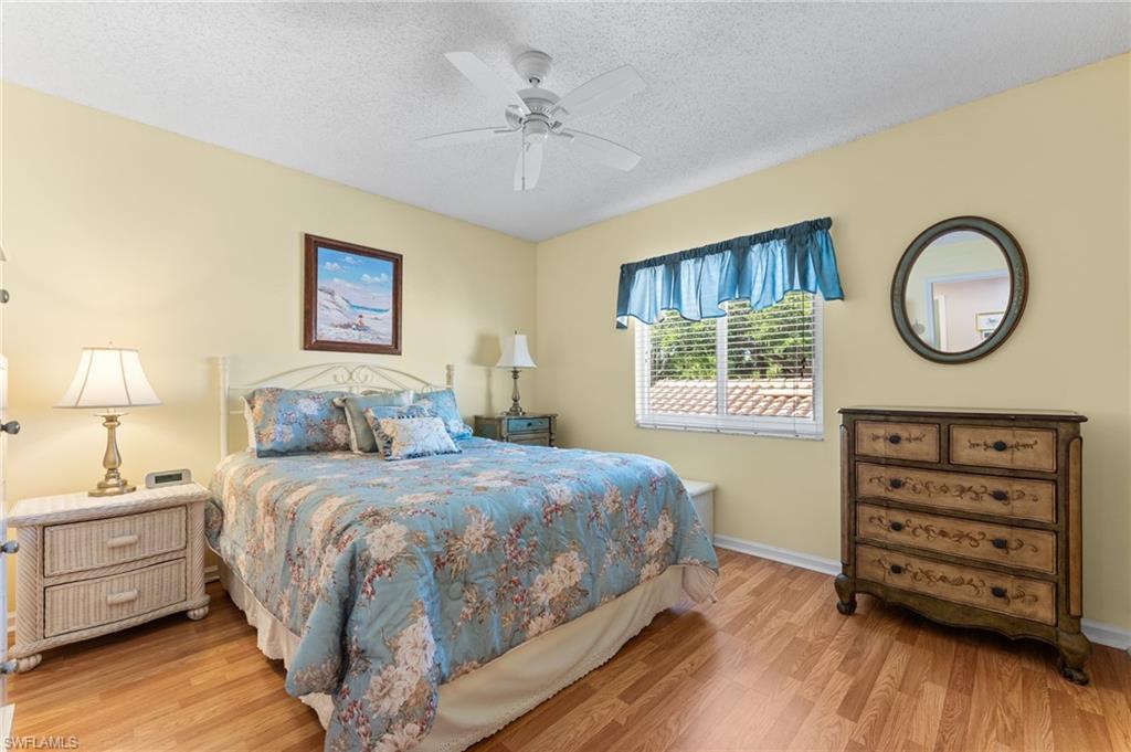 5928 Cranbrook Way, Unit D202 Naples, FL 34112 - Photo 10 of 23 Bedroom with ceiling fan, baseboards, wood finished floors, and a textured ceiling