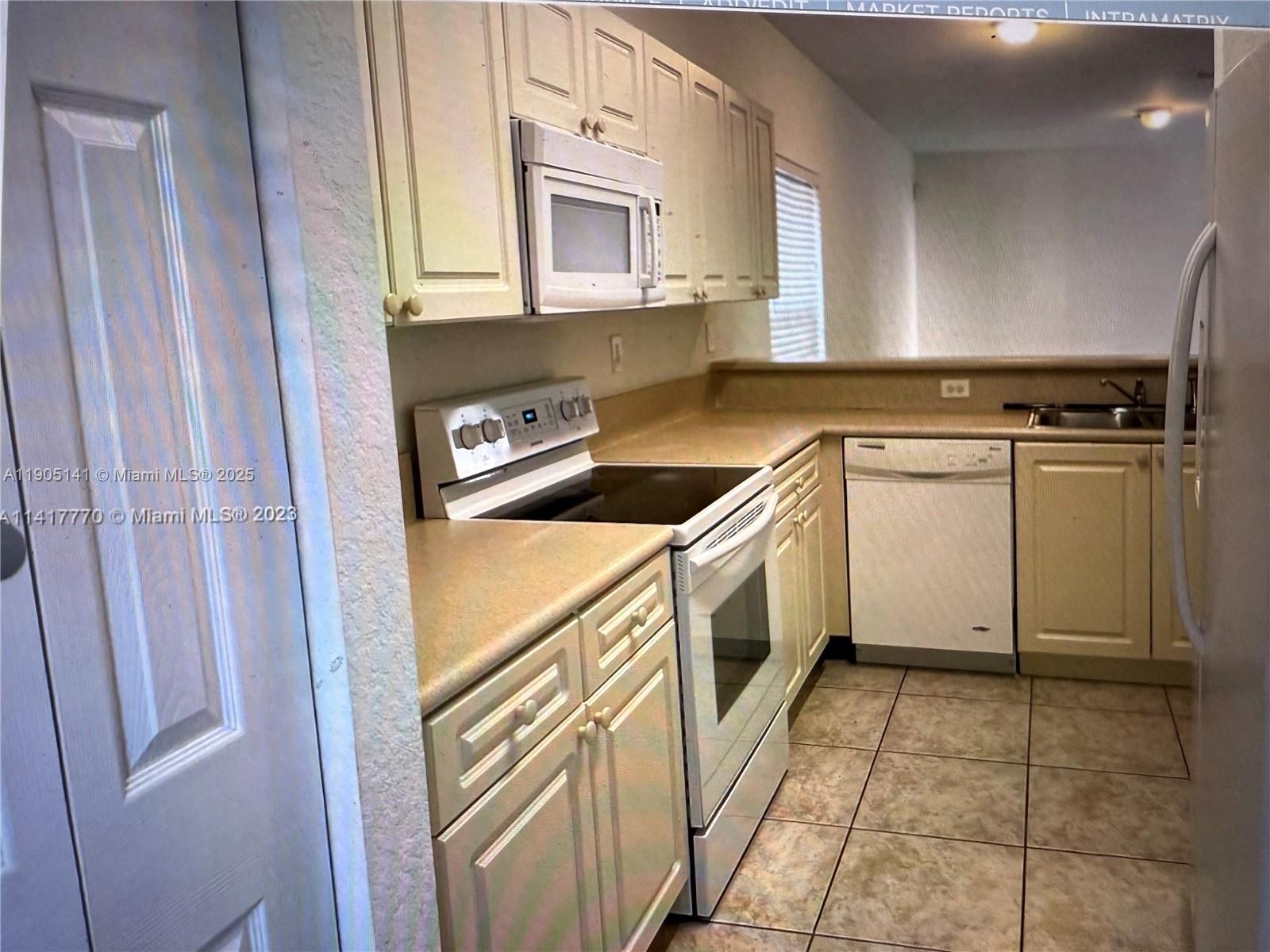 4932 Southwest 140th Terrace, Unit 1 Miramar, FL 33027 - Photo 11 of 27 a kitchen with a stove top oven and cabinets