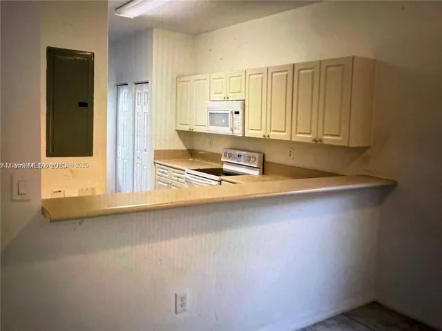 a kitchen with granite countertop a refrigerator and a stove