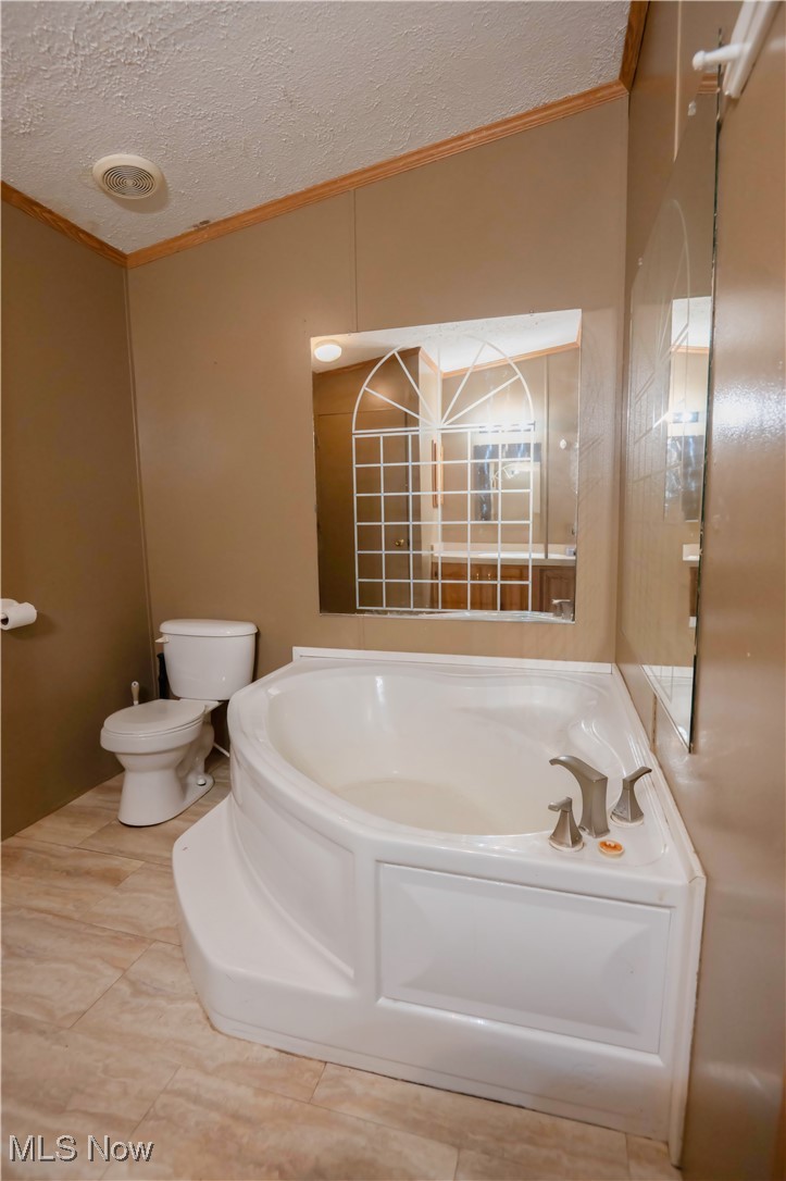 4594 Center Road Andover, OH 44003 - Photo 18 of 39 Full bathroom featuring crown molding, a garden tub, and a textured ceiling
