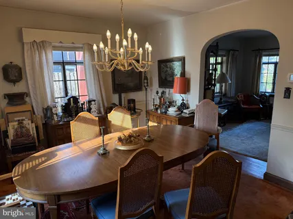 a view of a dining room with furniture a chandelier window and wooden floor