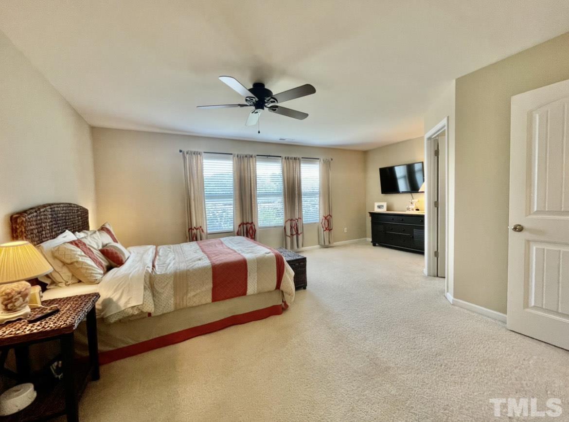 306 Leighann Ridge Lane Rolesville, NC 27571 - Photo 7 of 13 a spacious bedroom with a bed and a chandelier