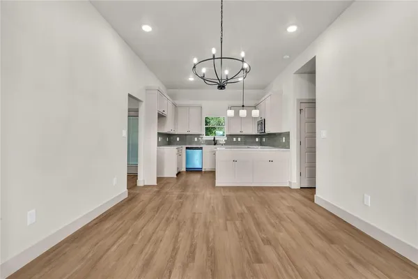 a large kitchen with granite countertop a large counter top a sink stainless steel appliances and cabinets