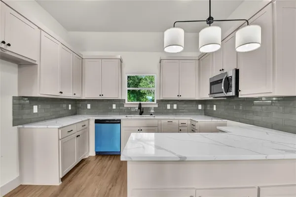 a kitchen with stainless steel appliances granite countertop a sink a stove top oven a counter space and cabinets