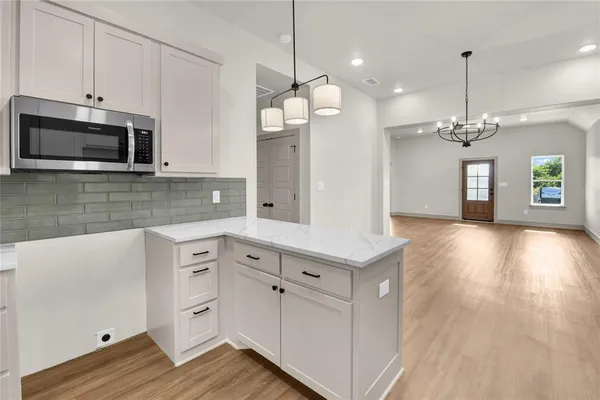 a kitchen with a sink microwave and cabinets
