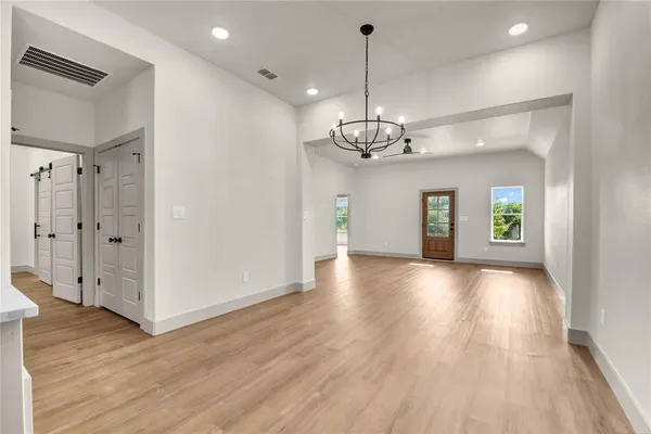 a view of a livingroom with wooden floor staircase and a kitchen space