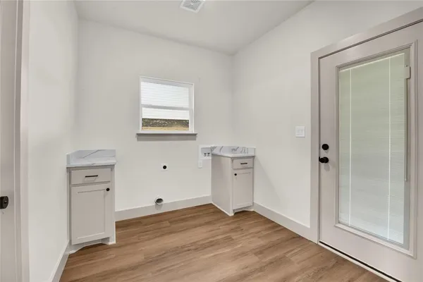 an empty room with wooden floor and cabinet
