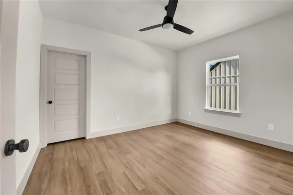 an empty room with wooden floor and windows