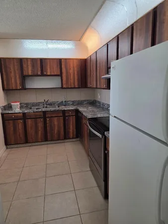 a kitchen with stainless steel appliances granite countertop a stove a refrigerator and a sink