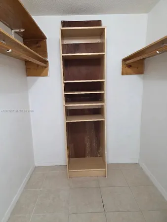 a view of walk in closet with empty racks