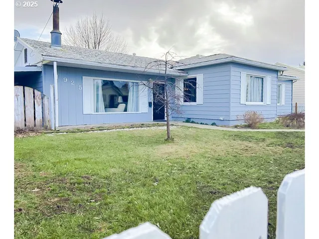 a view of a house with a yard and sitting area