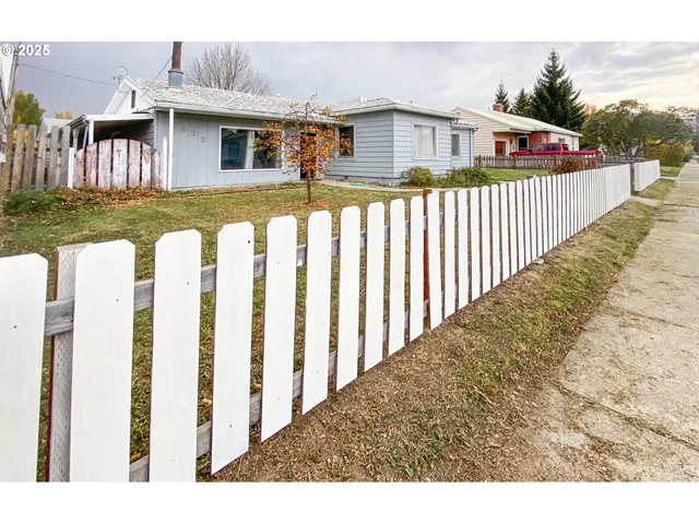 a front view of a house with wooden fence