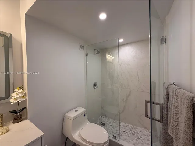 a bathroom with a toilet a sink and shower