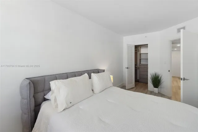 a bedroom with a bed and potted plant