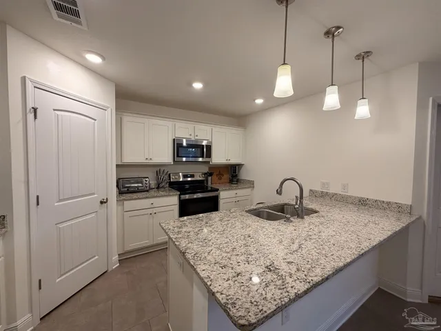 a kitchen with sink refrigerator and microwave