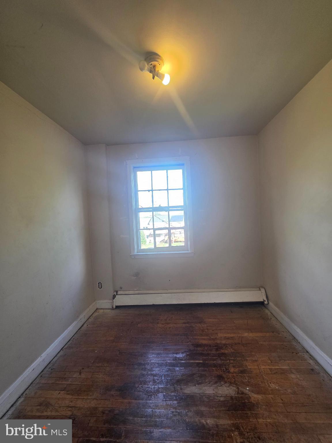 5933 Leith Walk Baltimore, MD 21239 - Photo 20 of 28 an empty room with wooden floor and windows