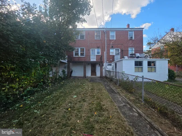 a view of a brick house next to a yard
