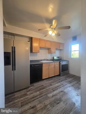 a kitchen with a sink cabinets stainless steel appliances and a window