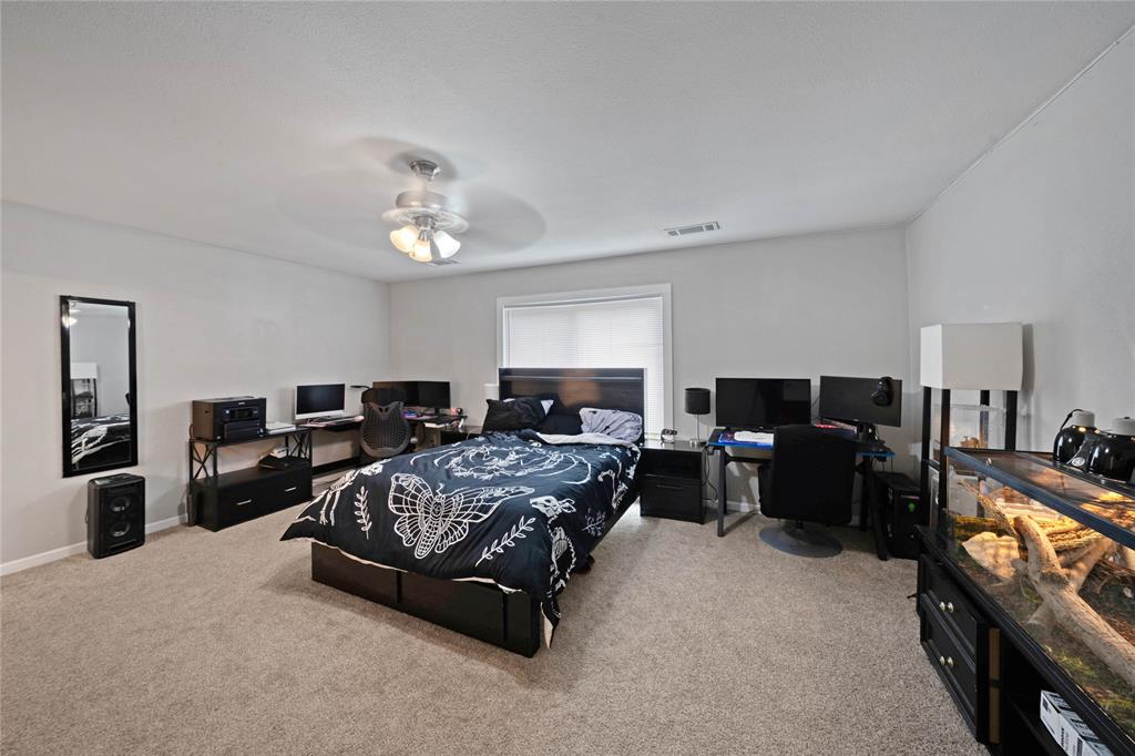1301 Thoreau Lane Allen, TX 75002 - Photo 12 of 31 a spacious bedroom with a bed and a chandelier