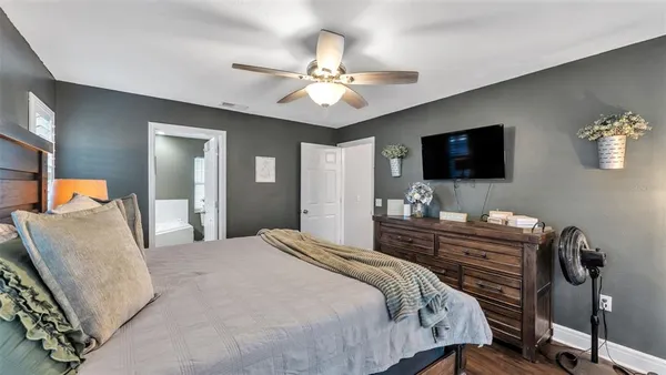 a bedroom with a bed and a flat tv screen on dresser