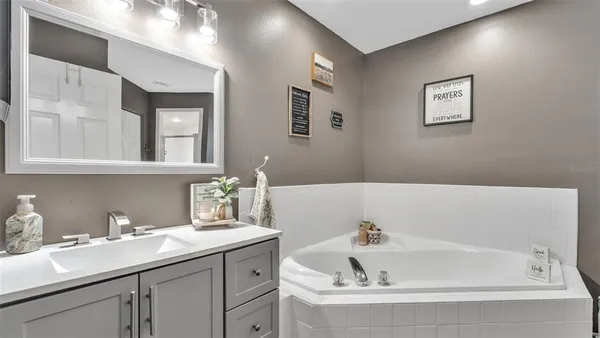 a bathroom with a tub sink and mirror