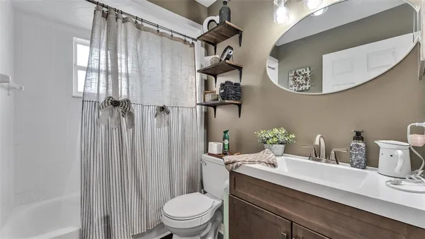 a bathroom with a granite countertop sink toilet a mirror and shower