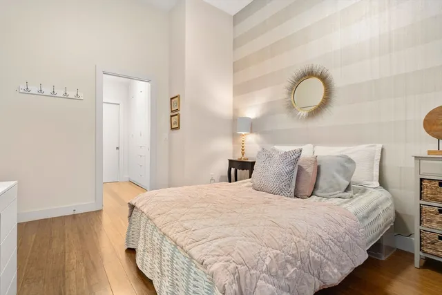 a bedroom with bed and wooden floor