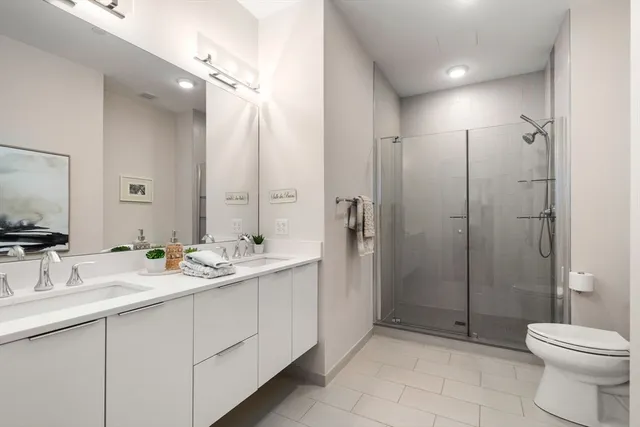 a bathroom with a double vanity sink toilet and shower