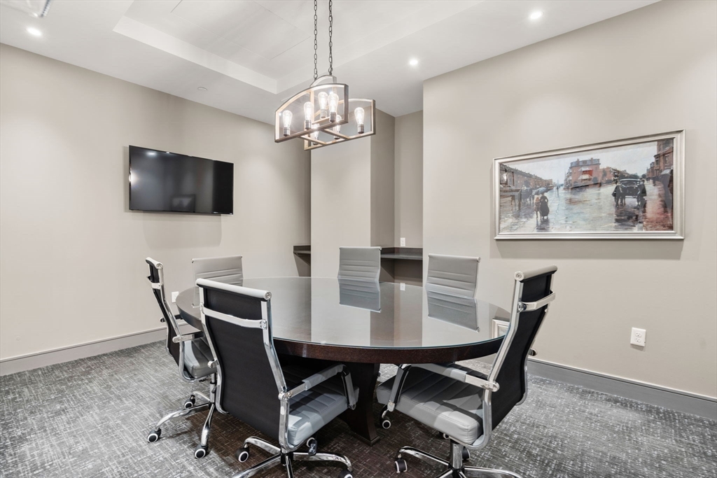 121-127 Portland Street, Unit 202 Boston, MA 02114 - Photo 18 of 25 a view of a dining room with furniture and a chandelier