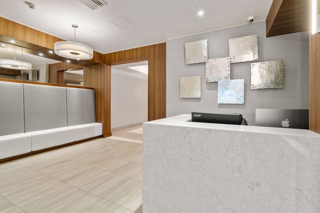 121-127 Portland Street, Unit 202 Boston, MA 02114 - Photo 21 of 25 a bedroom with a bed and a large mirror