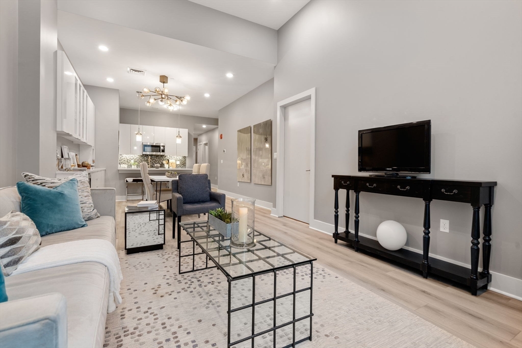 121-127 Portland Street, Unit 202 Boston, MA 02114 - Photo 5 of 25 a living room with furniture and a flat screen tv