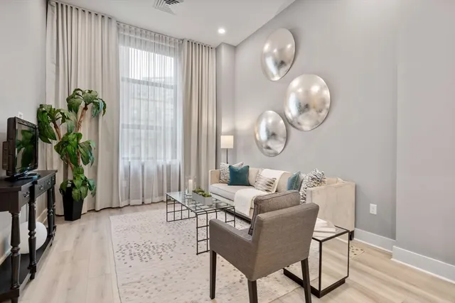 a living room with furniture potted plant and a large mirror