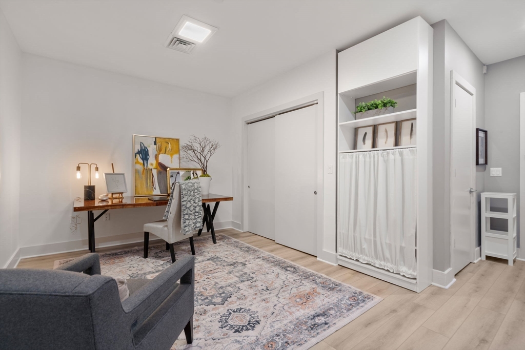 121-127 Portland Street, Unit 202 Boston, MA 02114 - Photo 9 of 25 a view of a livingroom with furniture and wooden floor