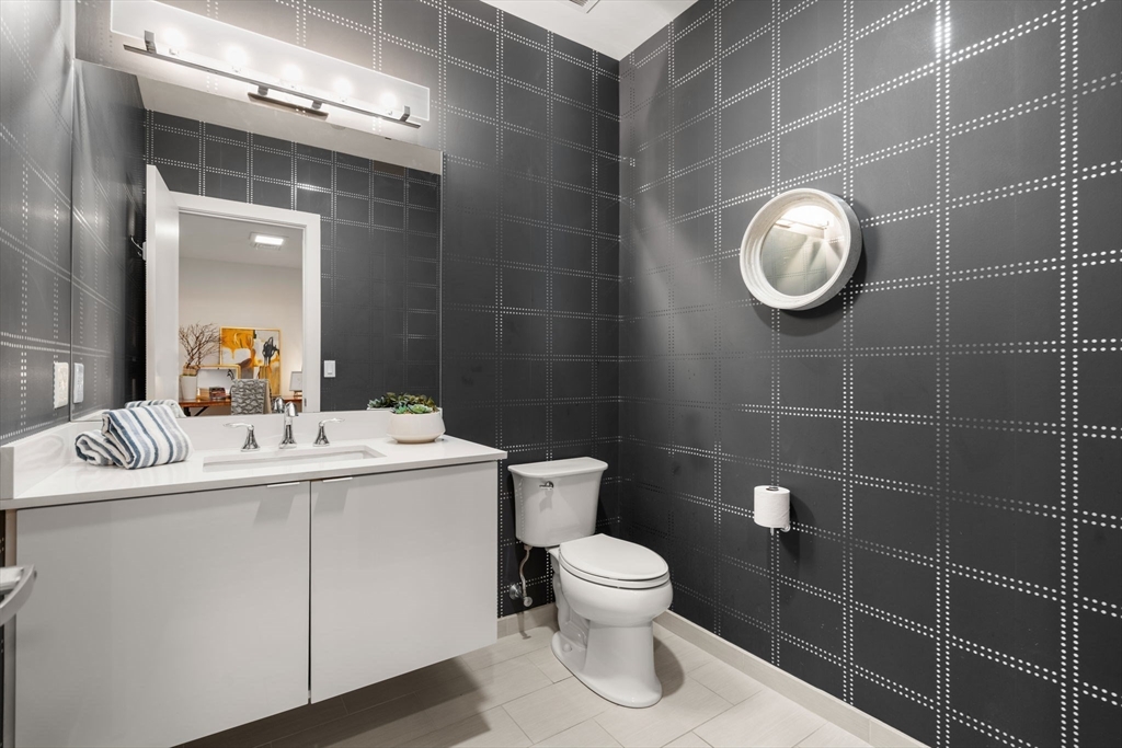 121-127 Portland Street, Unit 202 Boston, MA 02114 - Photo 10 of 25 a bathroom with a toilet a sink and mirror