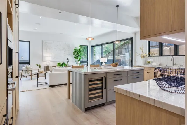 a kitchen with kitchen island granite countertop a stove a sink a dining table and chairs