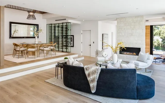 a living room with fireplace furniture and a large window