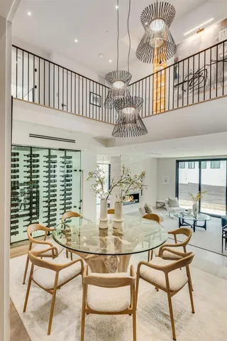 a view of a dining room and livingroom with furniture wooden floor and a chandelier