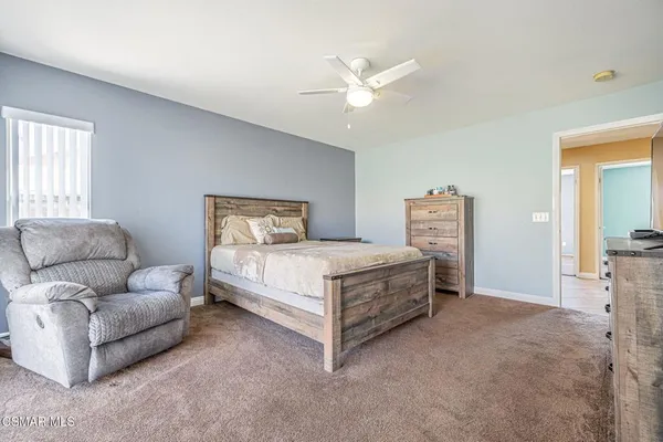 a bedroom with a bed flat screen tv and a window